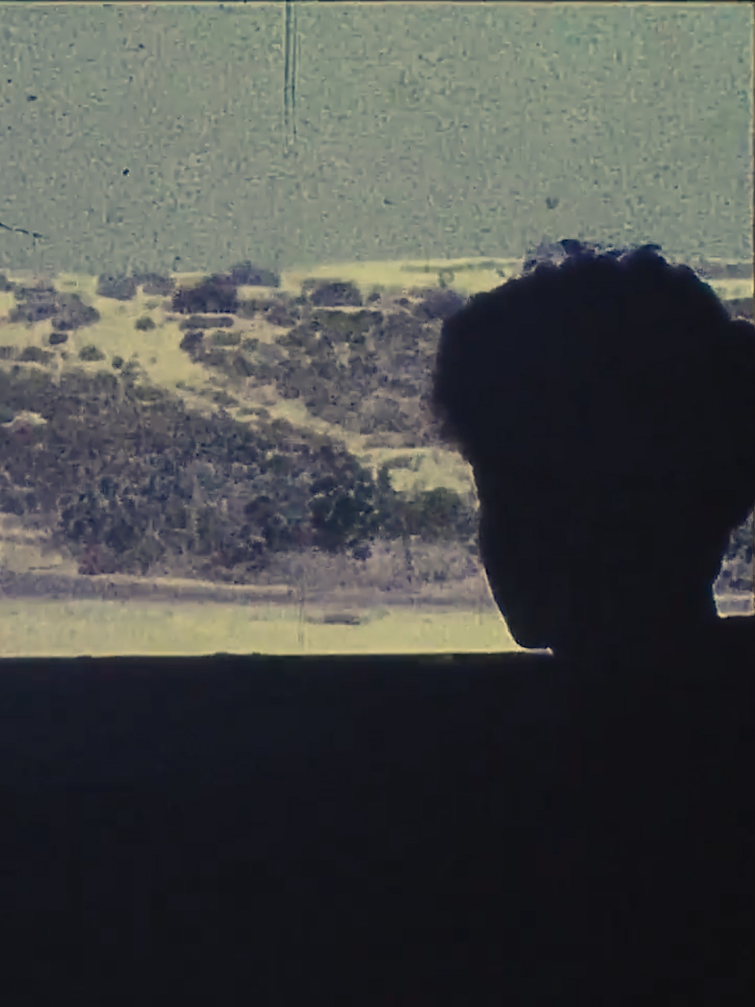 Silhouette looking through a window in an archival film frame