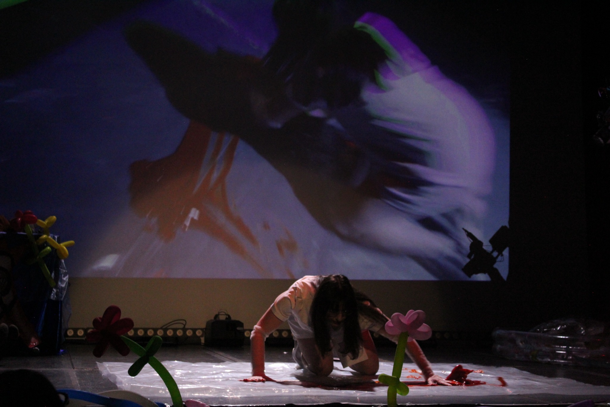 Performer onstage among balloon flowers